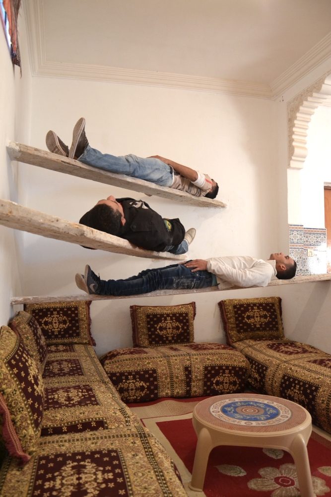 people laying down on wall shelves