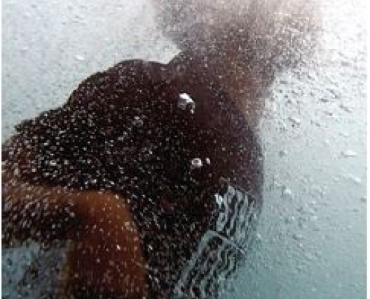 person swimming underwater to surface