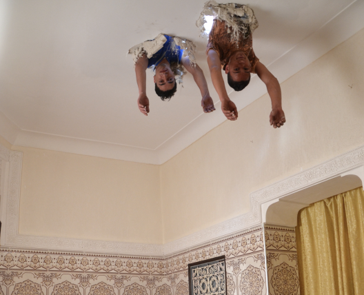 two people coming head first through a ceiling 