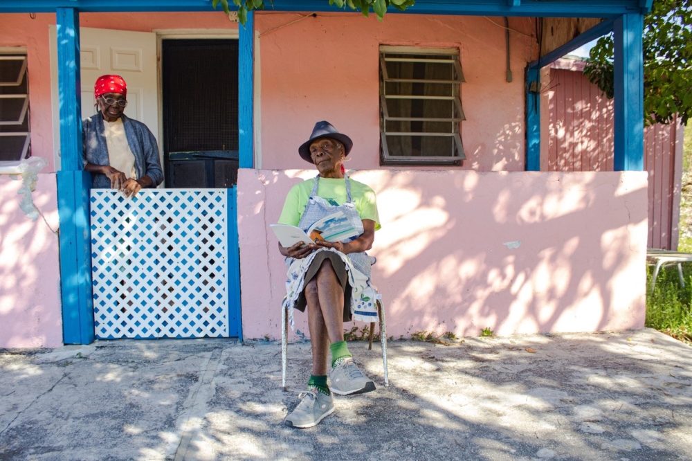 people sitting and standing on their porch