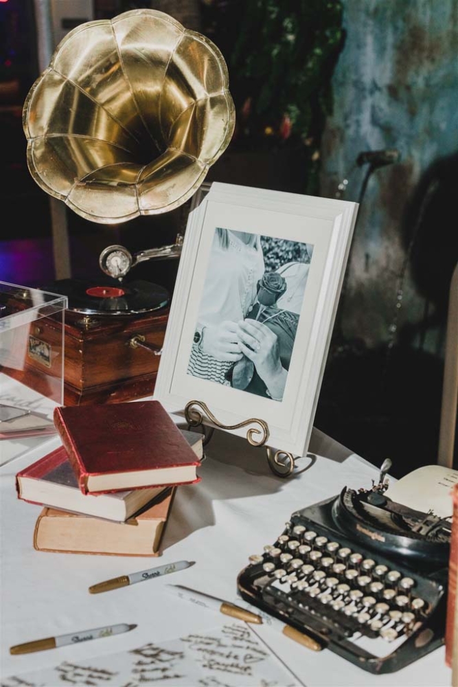 table with a typewriter, books, and a phonograph
