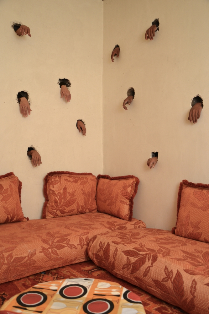 living space with hands coming from the walls