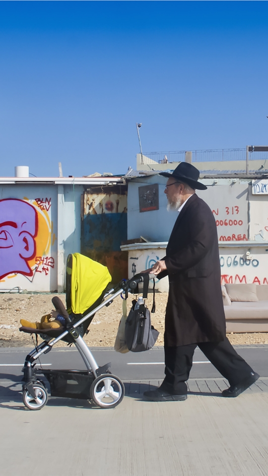 man pushing a baby carriage 