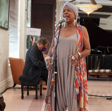 woman wearing a grey dress singing