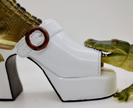 two crocodiles toys eating a shoe