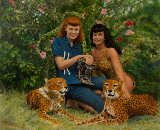 two women sitting with cheetahs 