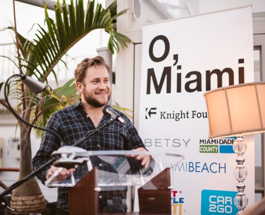 man speaking to a crowd of people